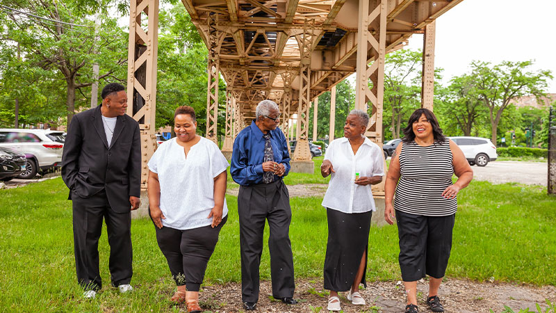 A diverse group of individuals standing together in a serene park, enjoying nature's beauty and each other's company.